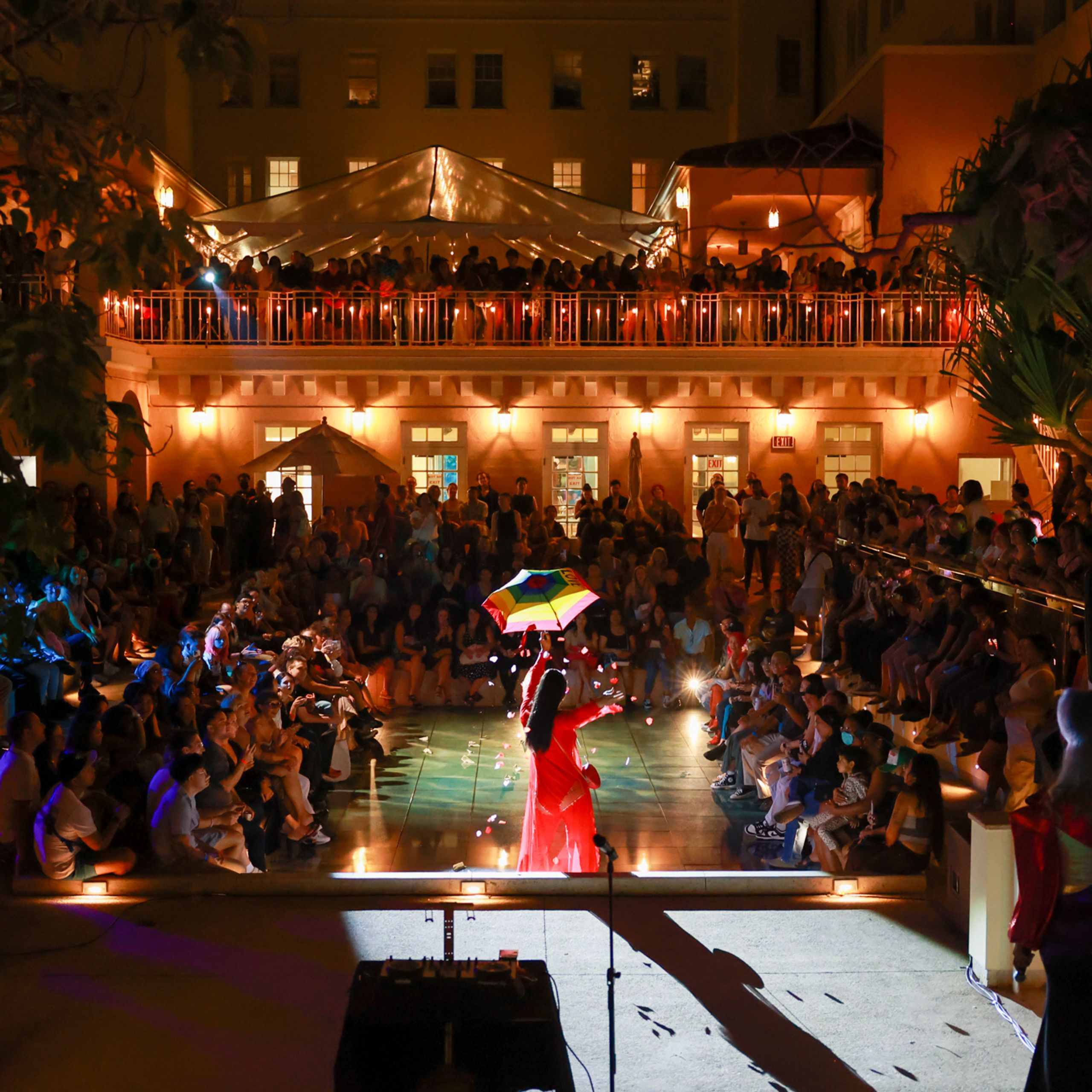 Performers and audience in outdoor space at night.