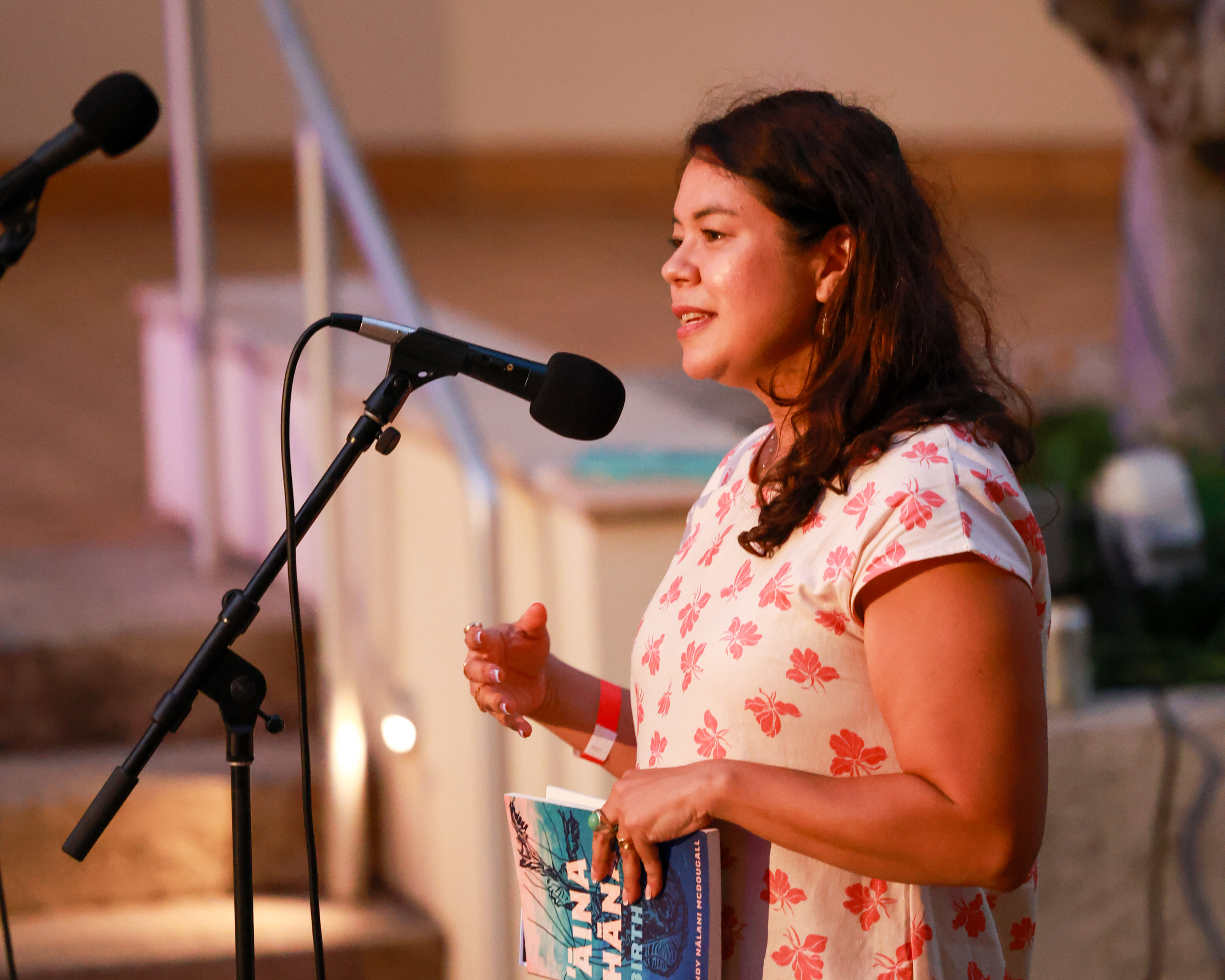 Hawaiʻi State Poet Laureate, Dr. Brandy Nālani McDougall, speaking into a microphone.