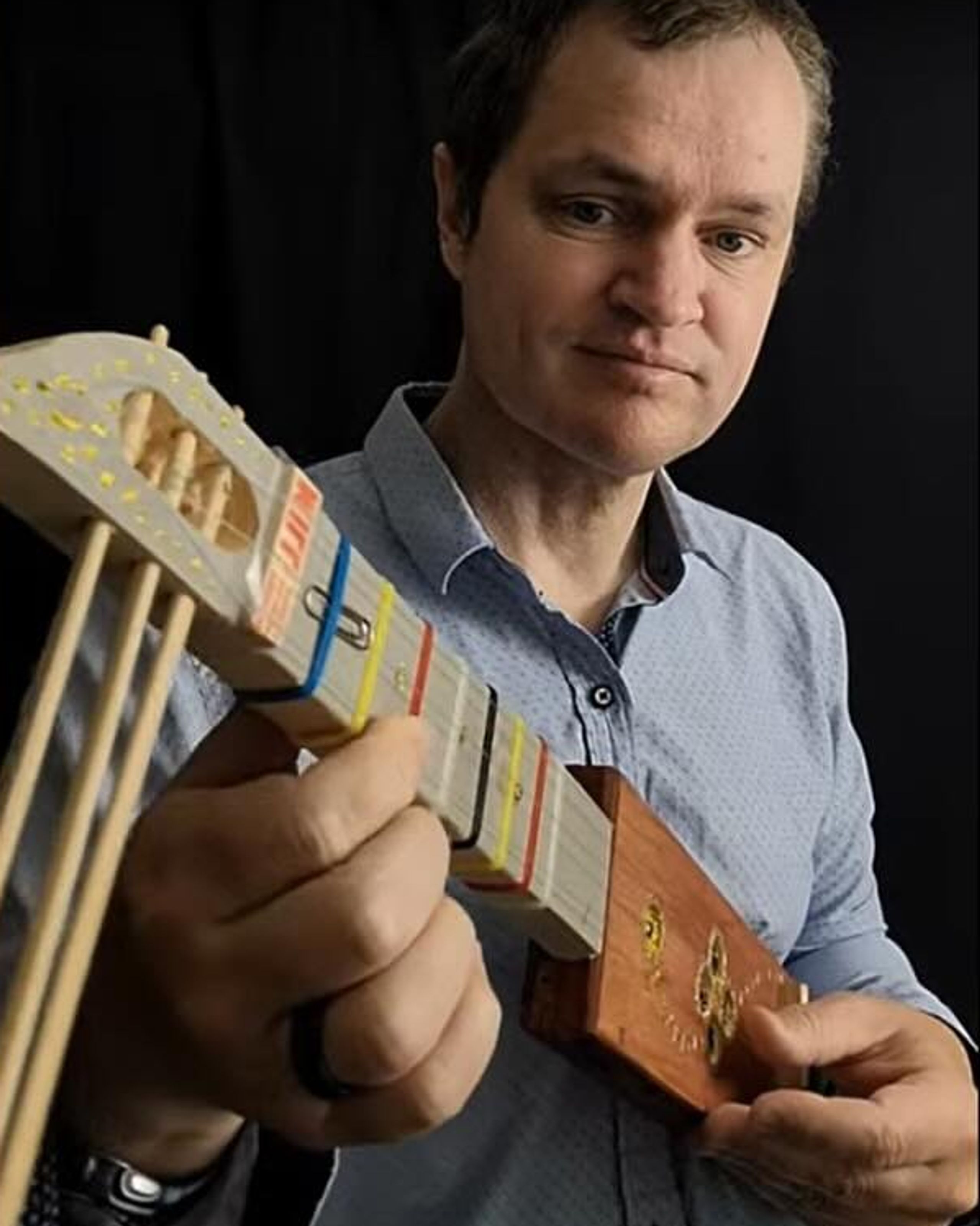 photo of artist holding a musical instrument