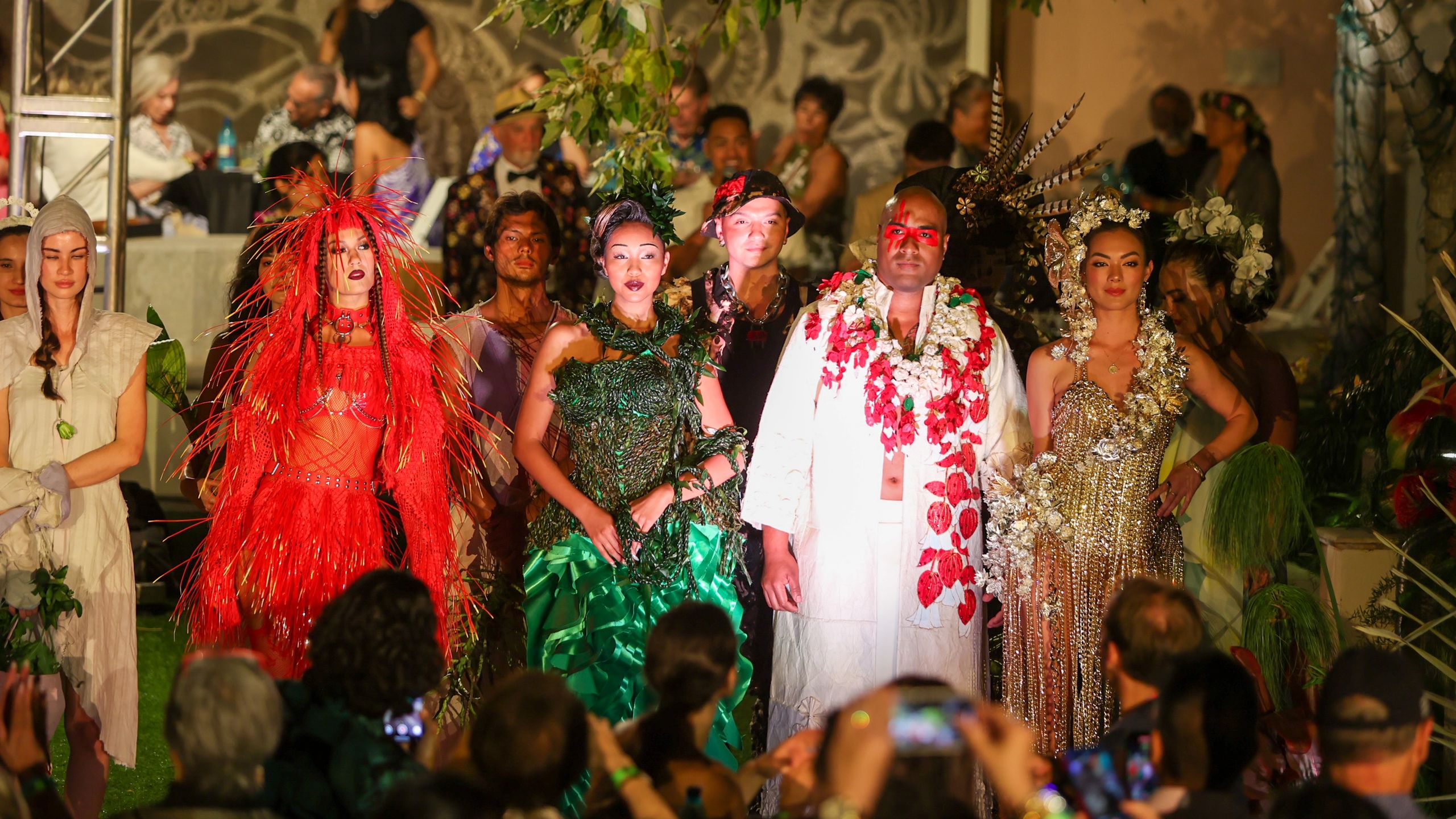 Four models in botanical looks are surrounded by a crowd