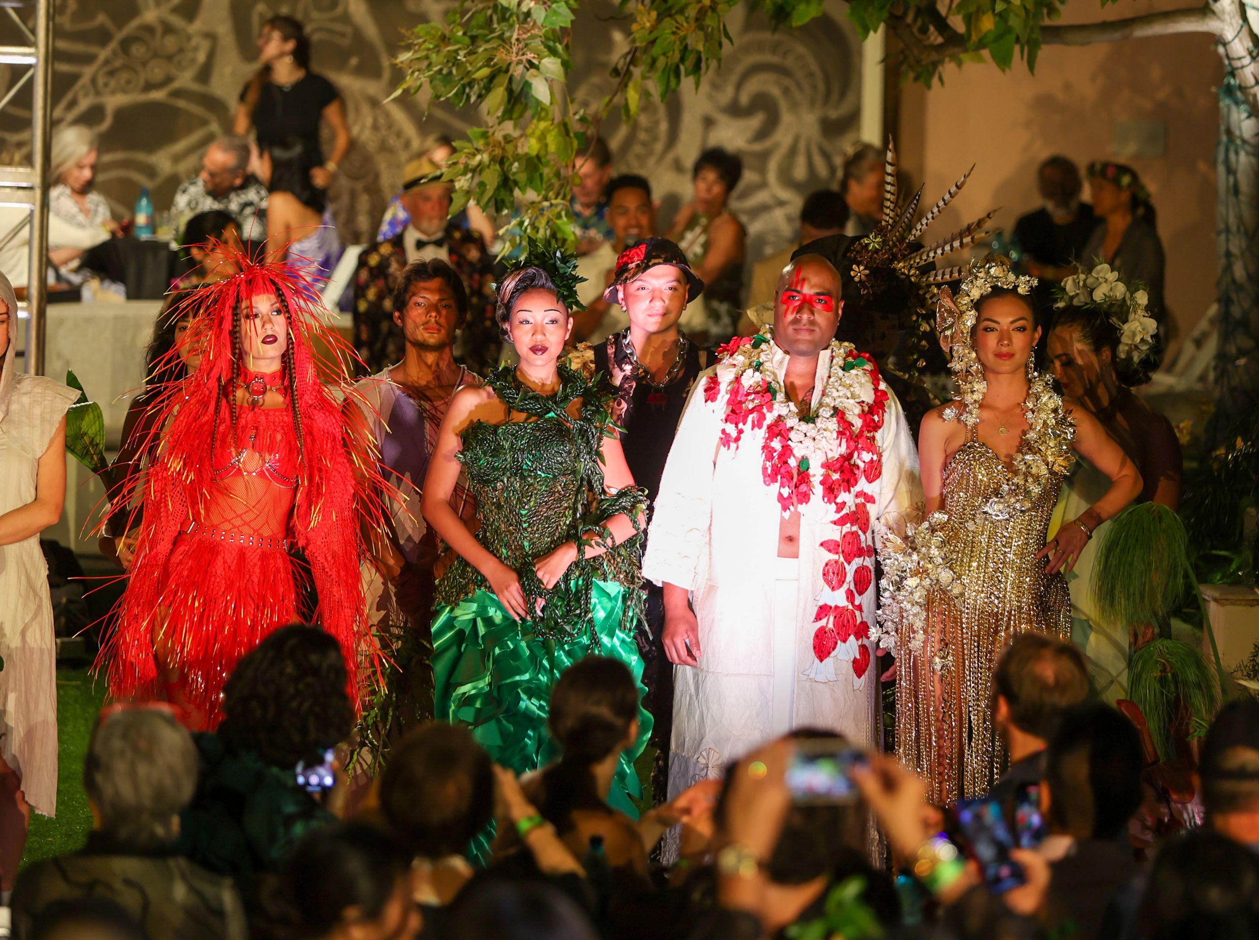 Four models in botanical looks are surrounded by a crowd