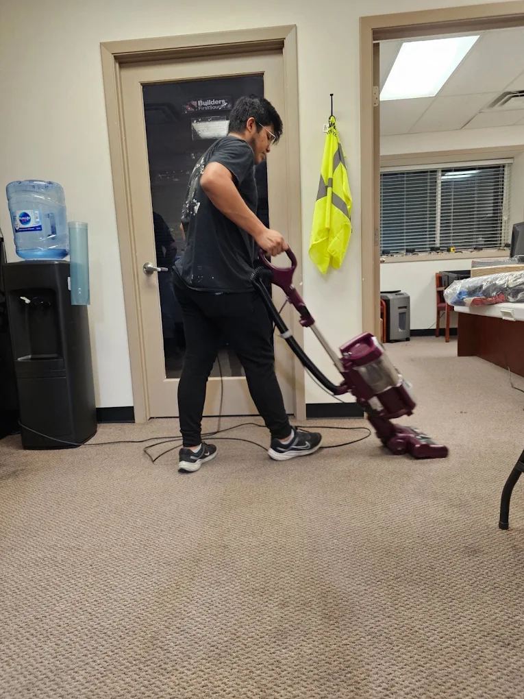 Team member vacuuming high-traffic carpet with professional equipment