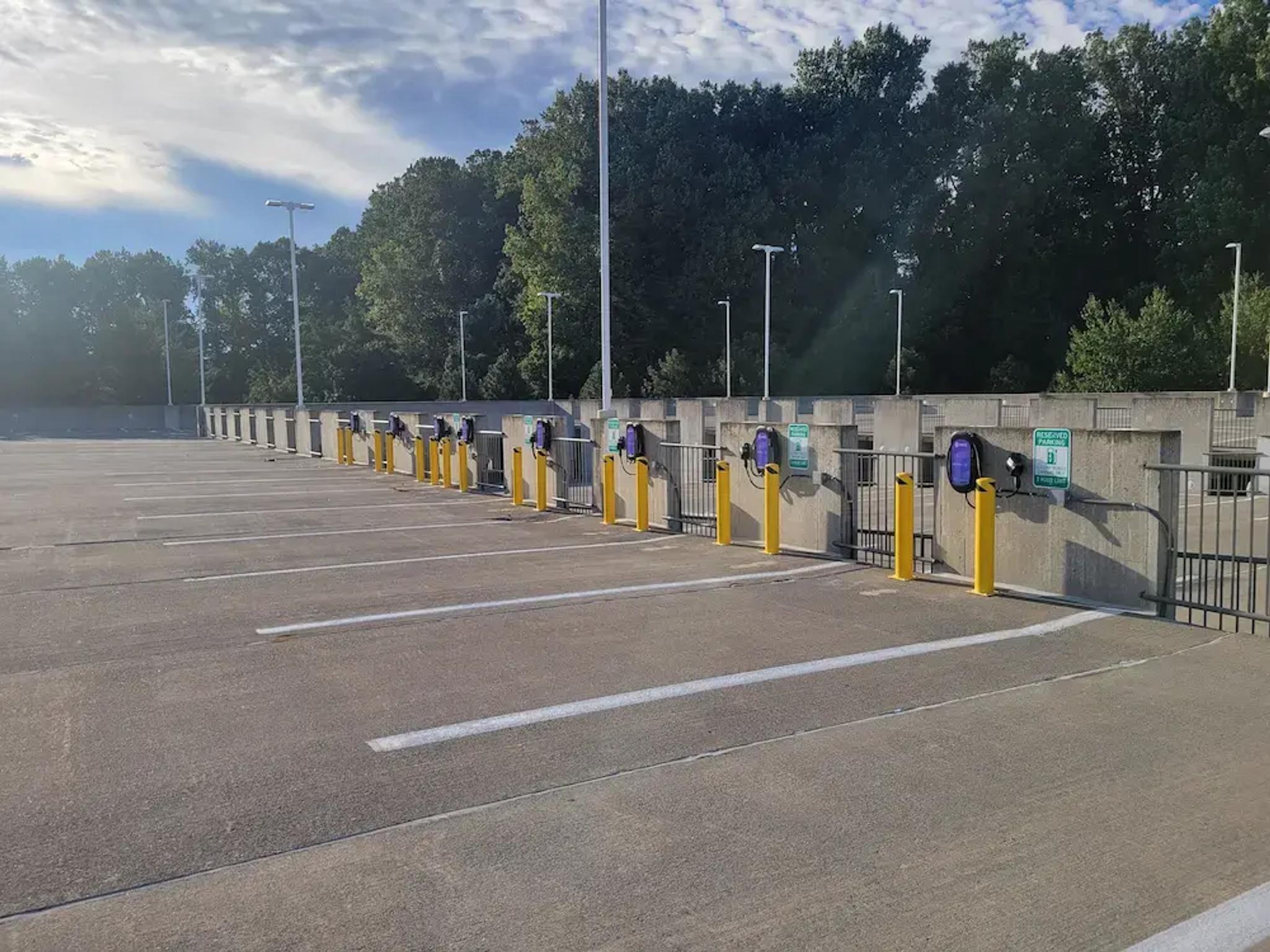 a row of electric vehicle charging stations in a parking garage .