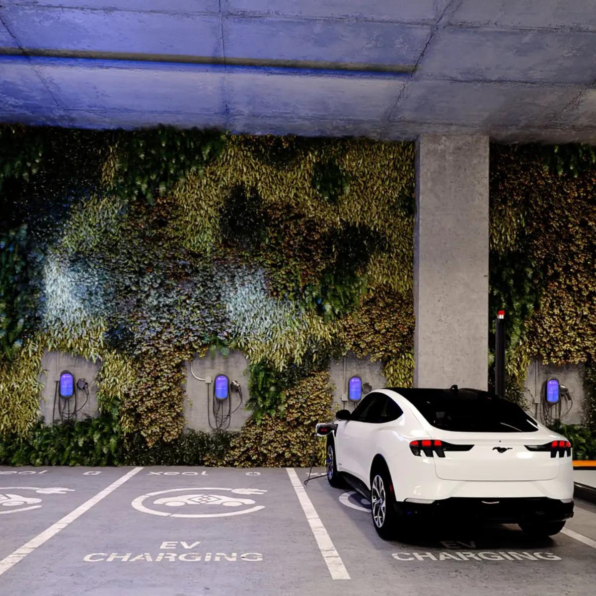 a white electric car is charging in a parking garage .