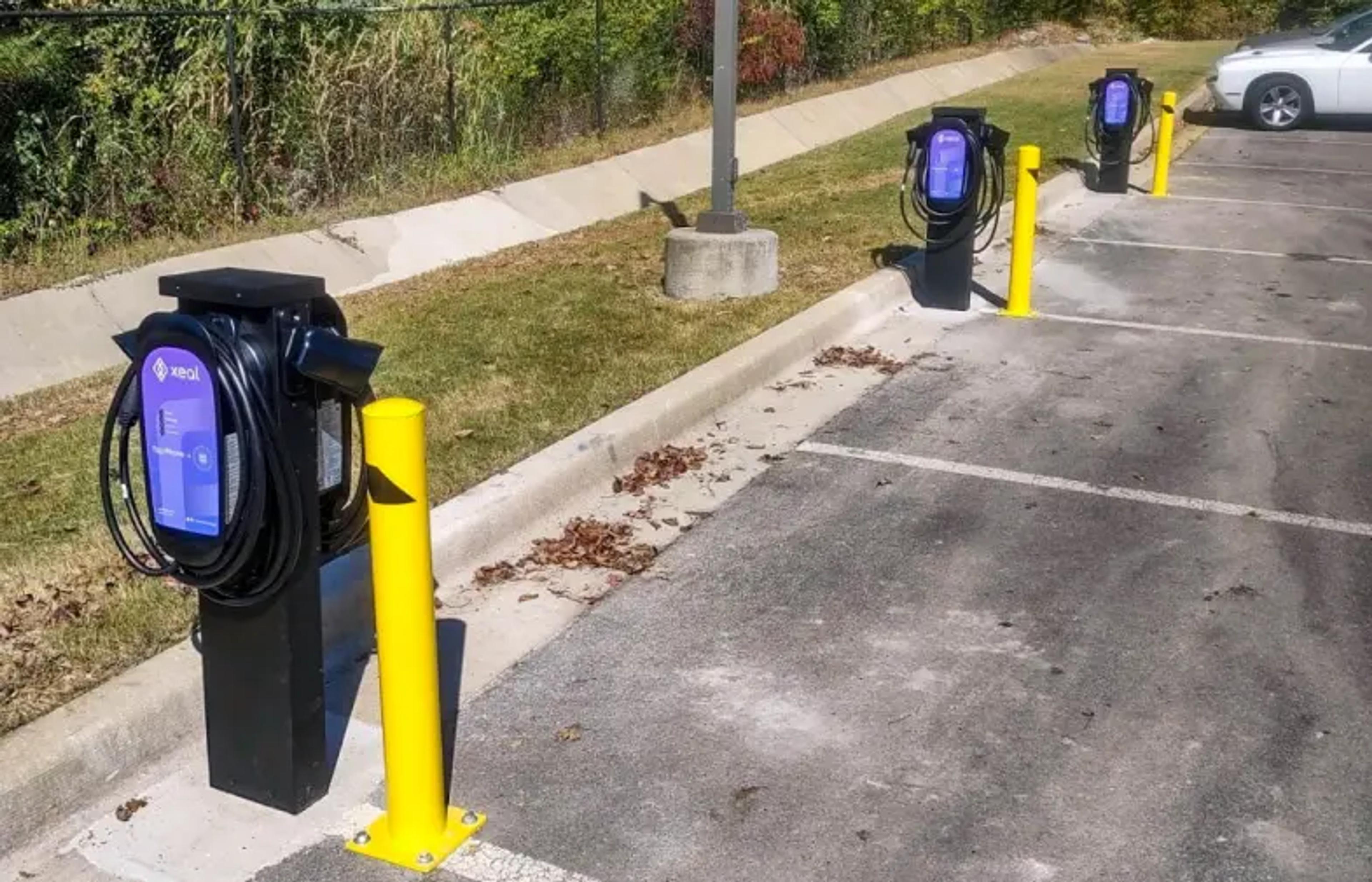 a row of electric vehicle charging stations in a parking lot .
