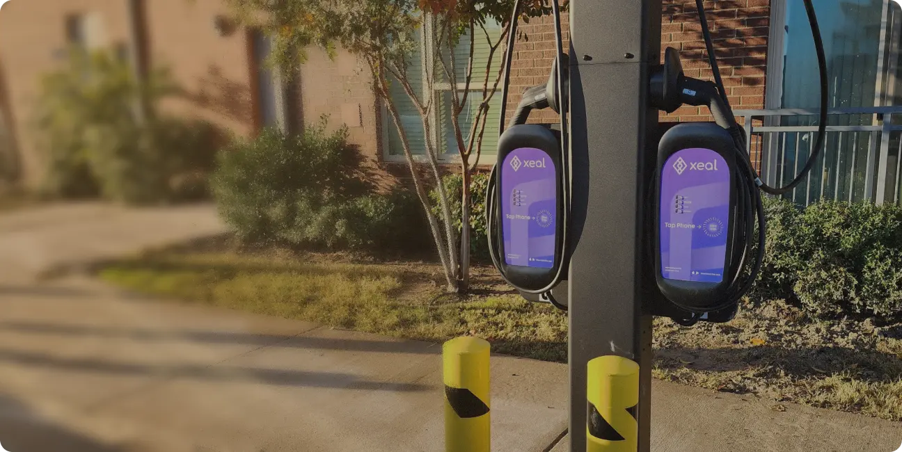 two xeal charging stations on a sidewalk in front of a building