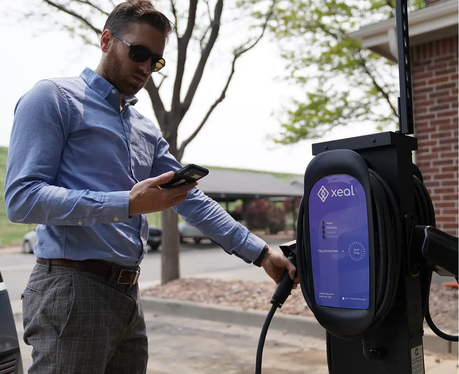 Man using Xeal app on cellphone after using Xeal charger