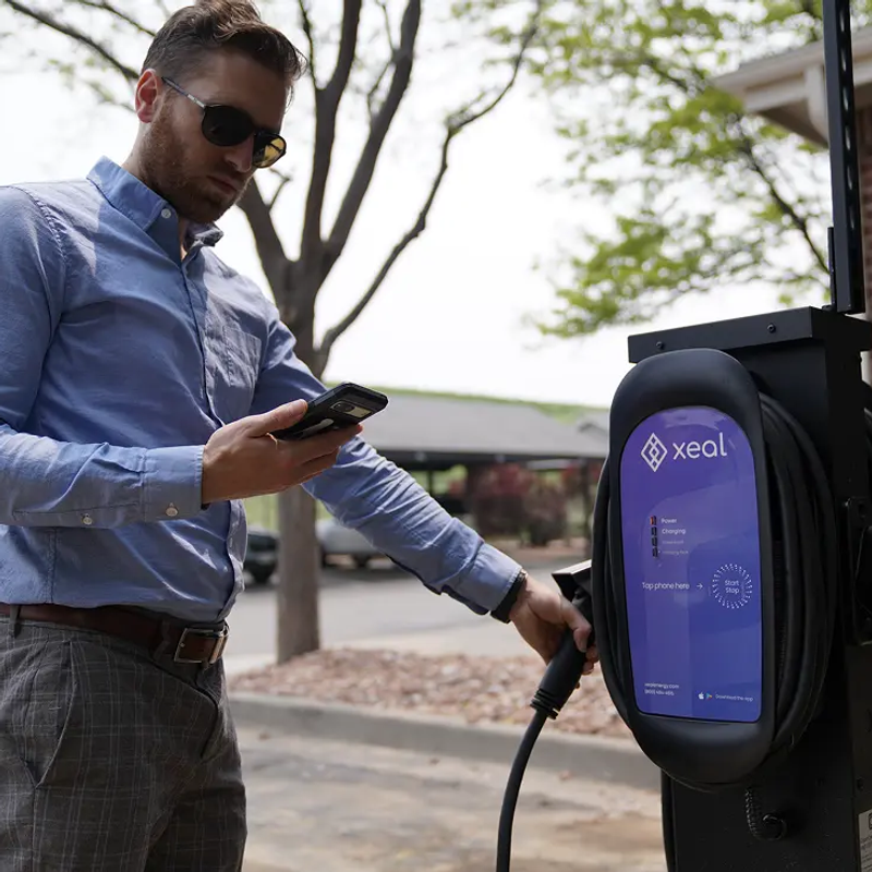 Man using Xeal charger and look at phone