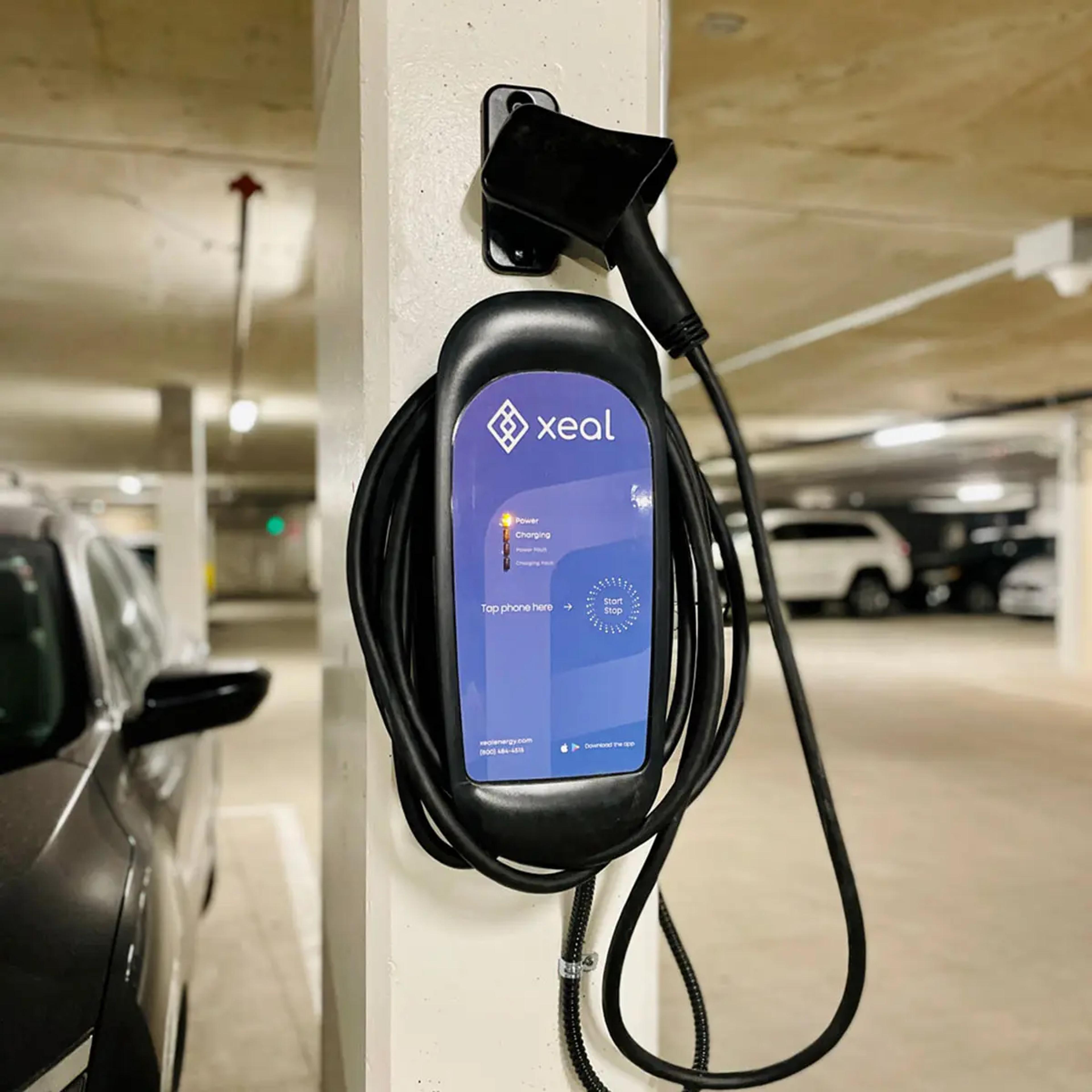 a car is being charged at a charging station in a parking garage .