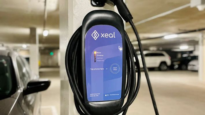 a car is being charged at a charging station in a parking garage .