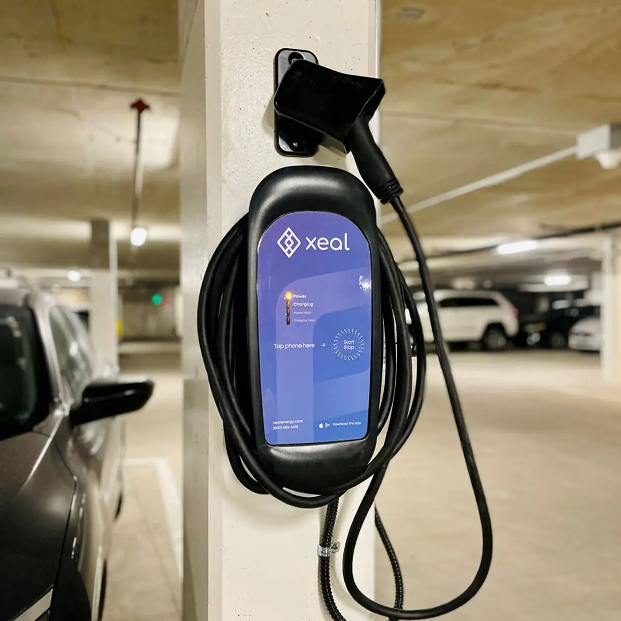 a car is being charged at a charging station in a parking garage .