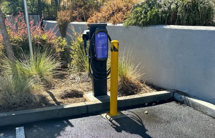an electric vehicle charging station in a parking lot .