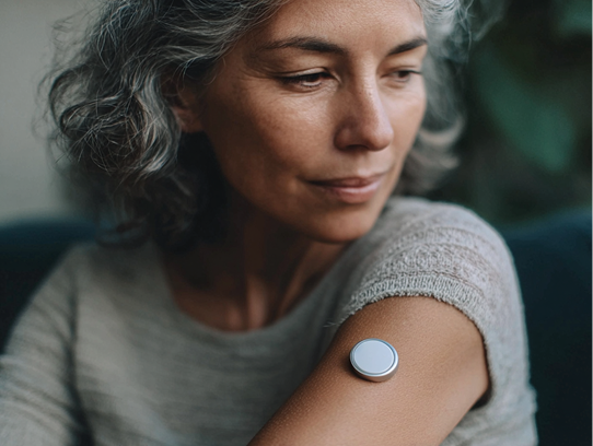 Woman wearing CGM monitor on arm
