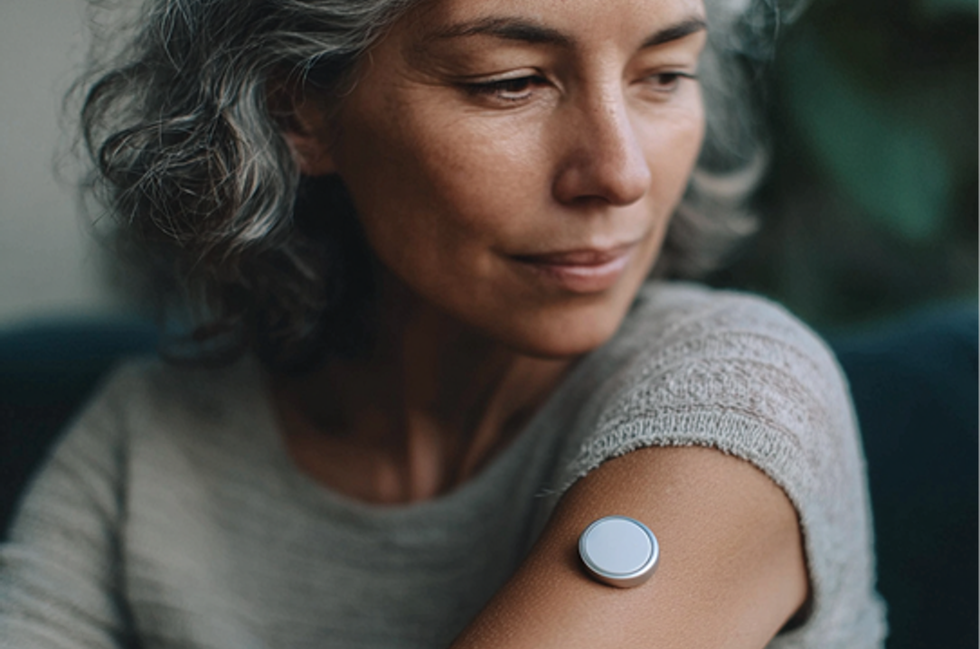 Woman wearing CGM monitor on arm