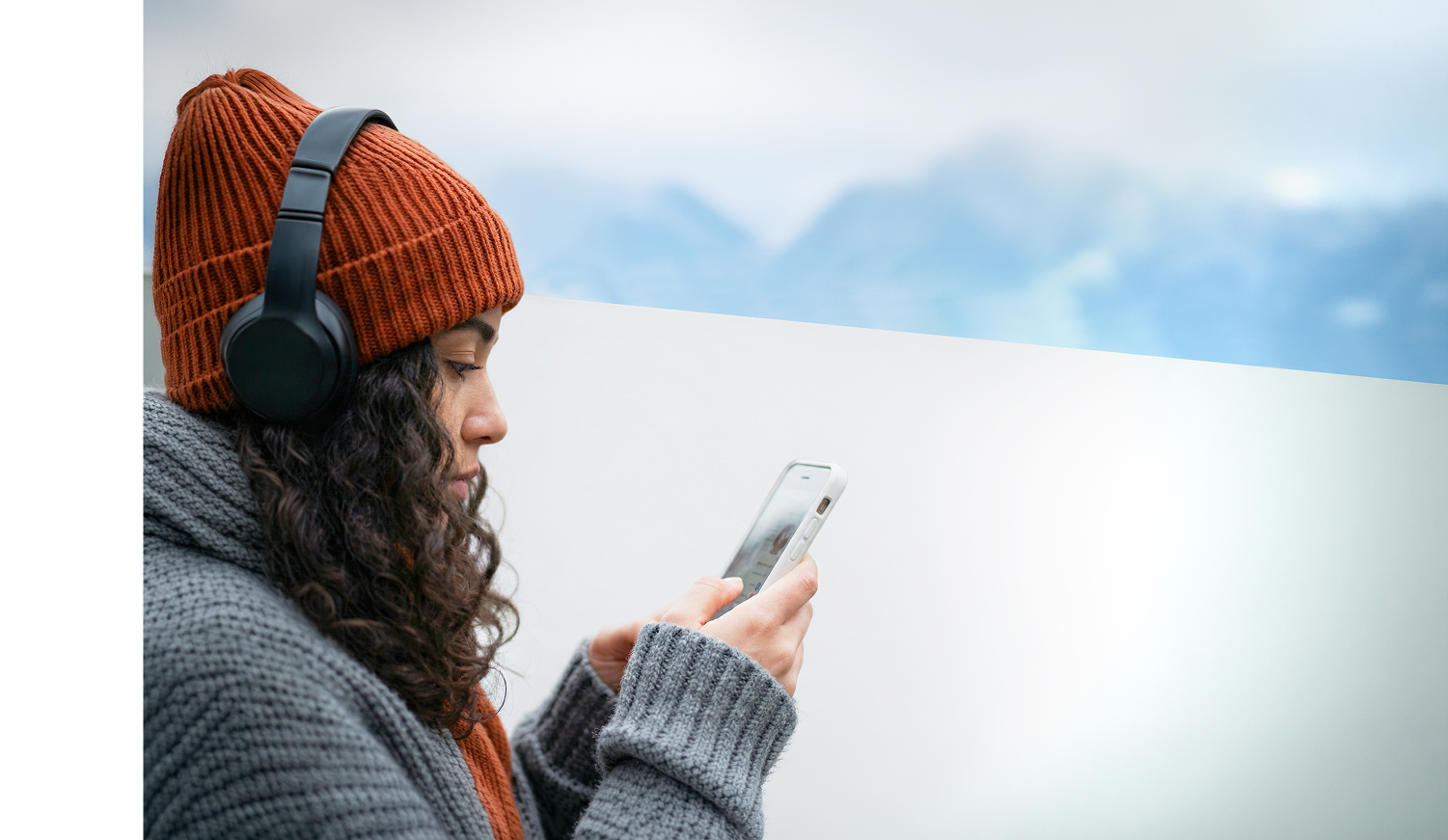 Woman looking at phone with headphones on