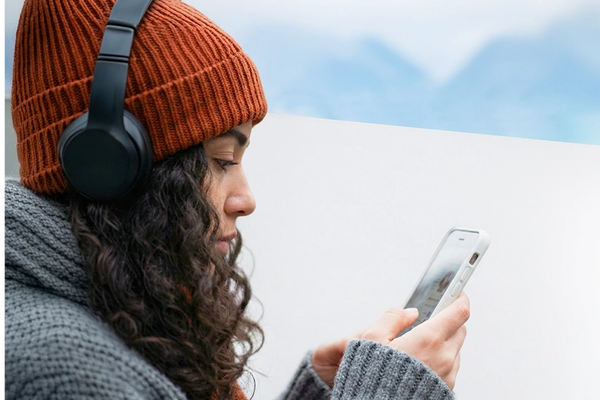 Woman looking at phone with headphones on