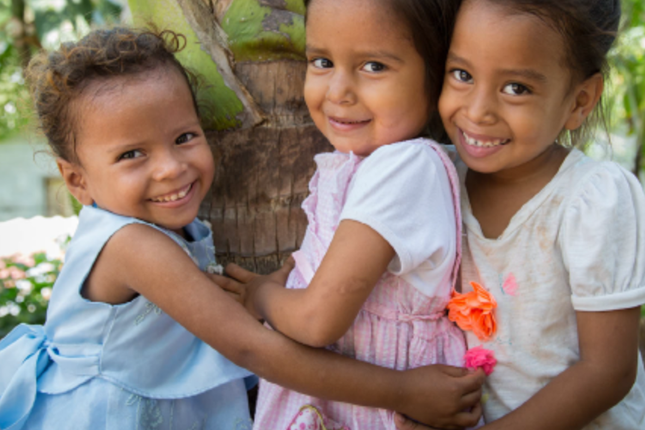 Photo of 3 children smiling at camera