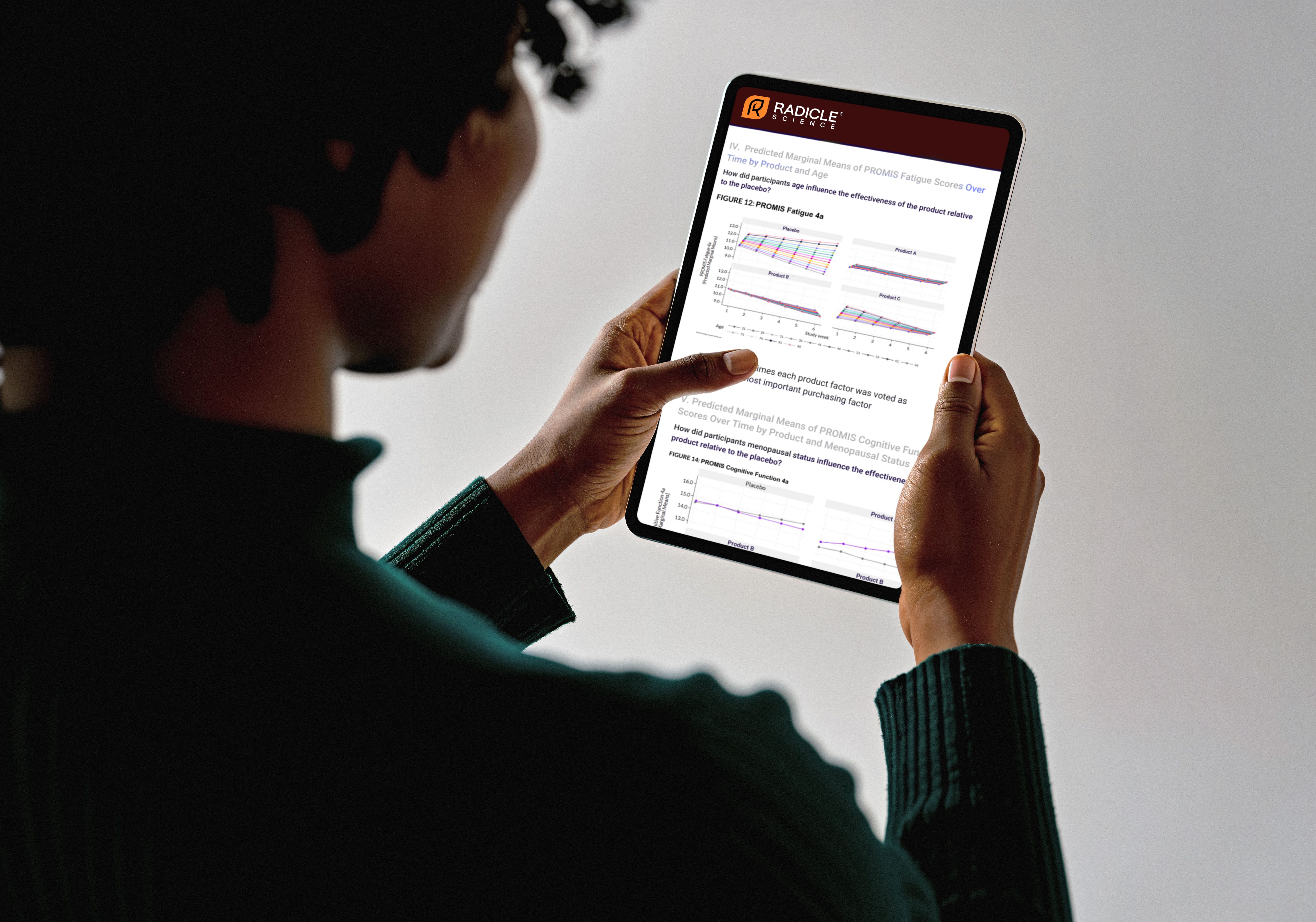 Person holding tablet with data analysis reports