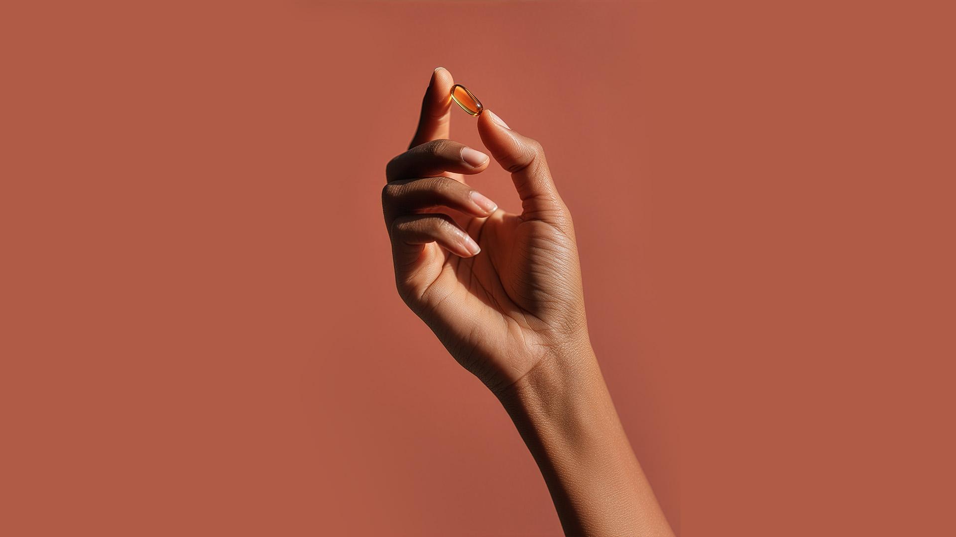 Hand holding translucent supplement pill