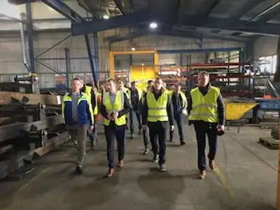 Tootmisjuhtimise koolituse osalejad tehasekülastusel tootmisalal - meeskonnavaim ja huvi