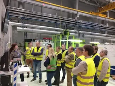 Tootmisjuhtimise arenguprogrammi osalejad kuulamas tehase töökorralduse ja visuaalse juhtimise tutvustust