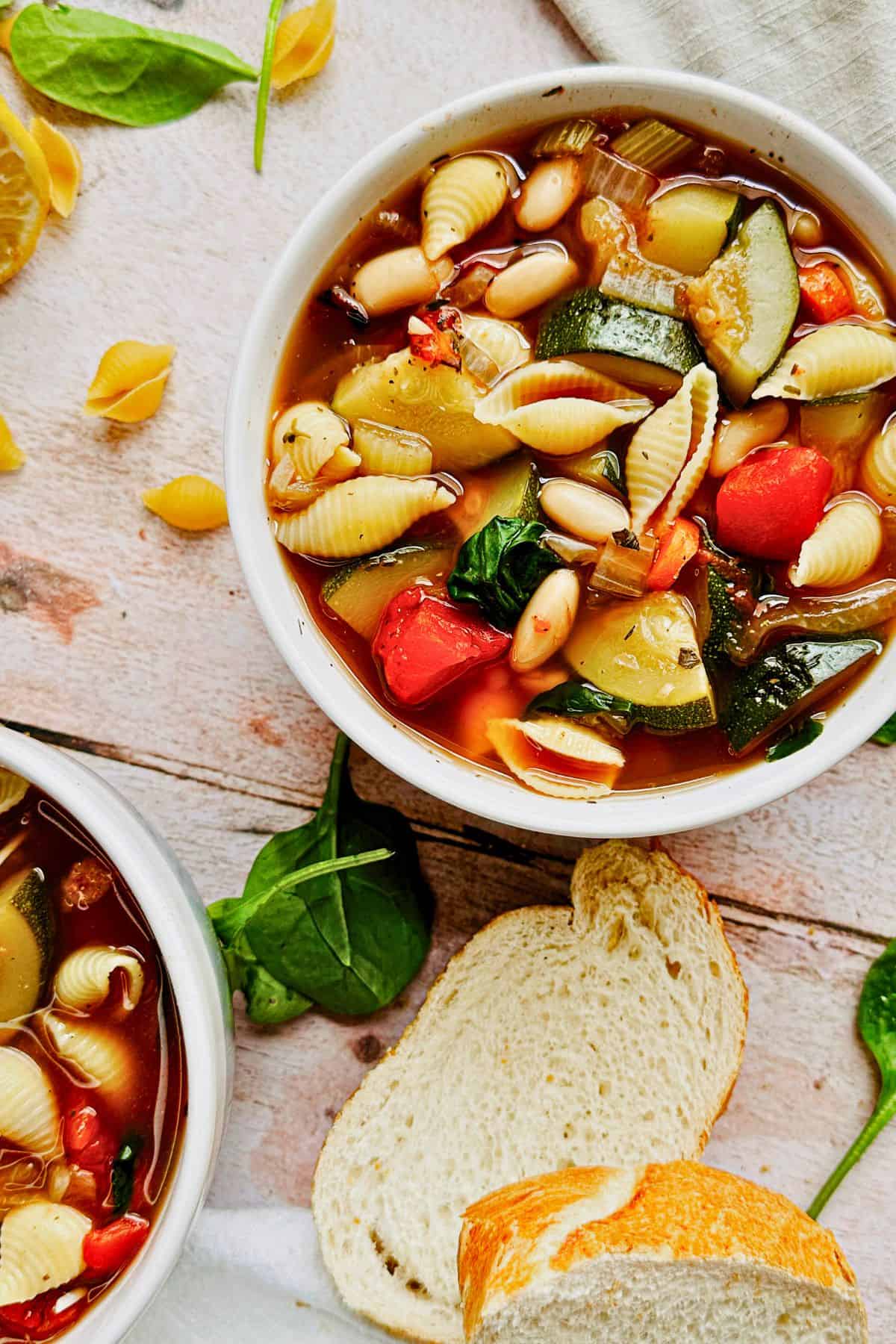 Vegan minestrone in a bowl, and a slice of bread.