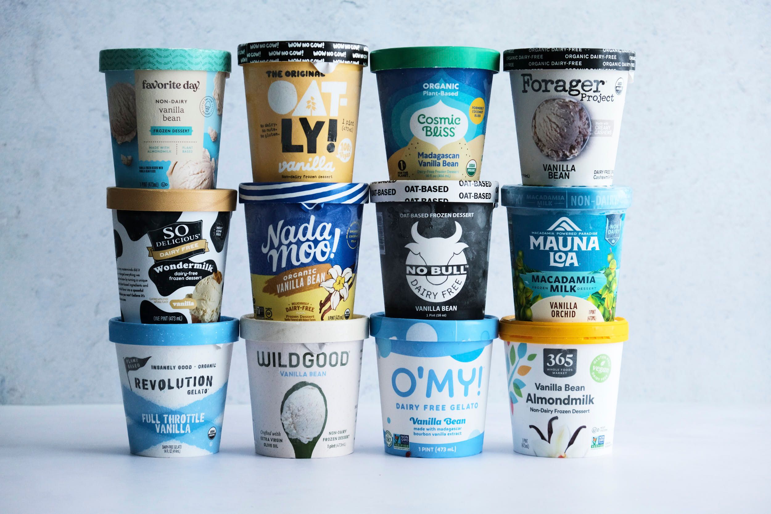 12 pints of different vegan vanilla ice cream brands stacked 3 pints high, 4 pints wide