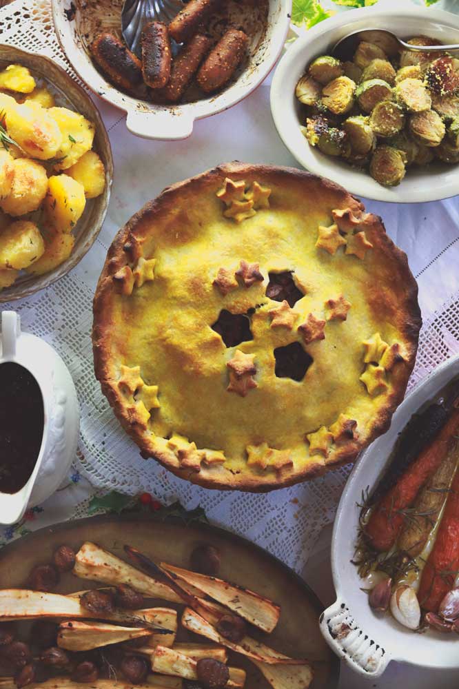 Vegan mushroom bourguignon on a table with vegan holiday side dishes.