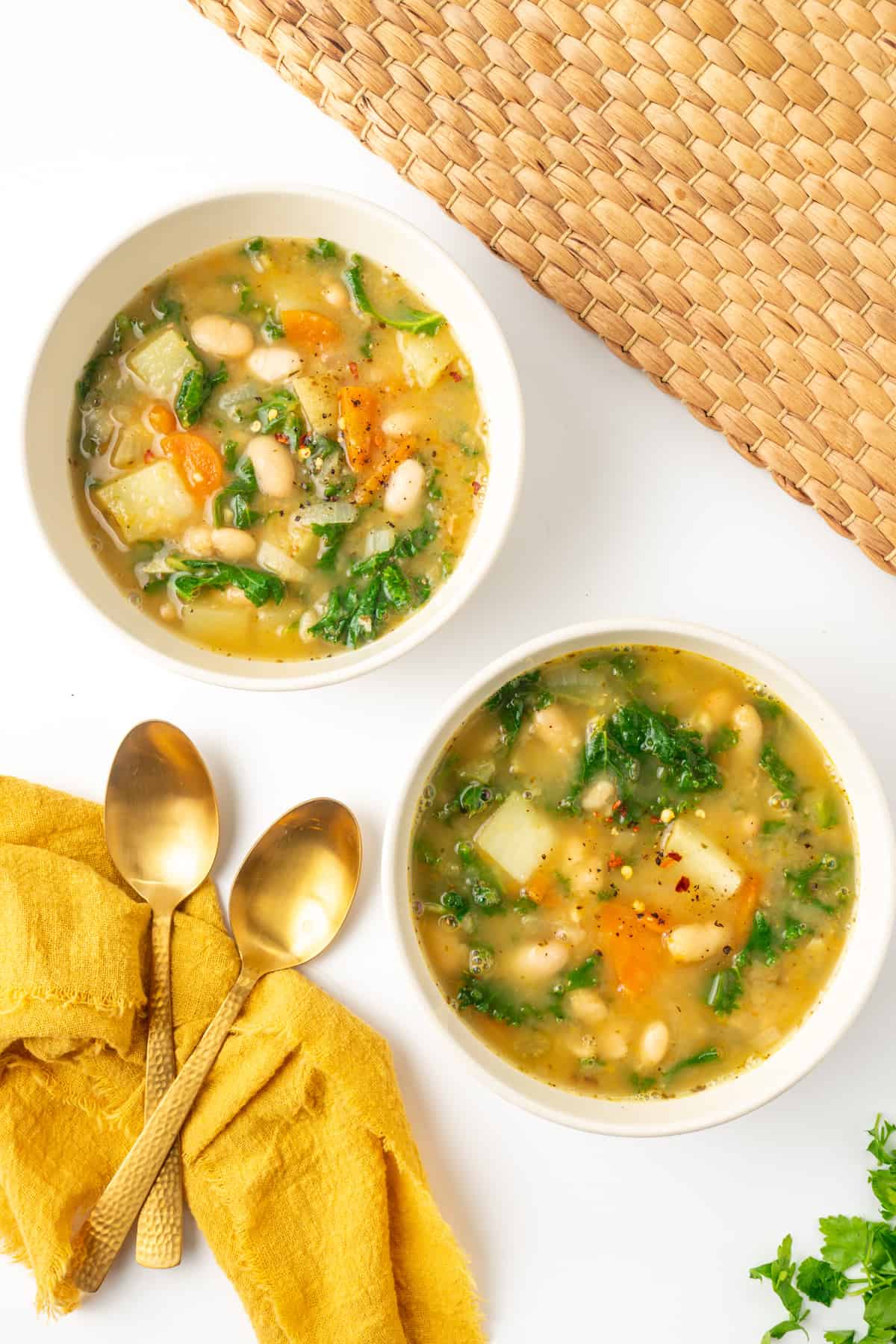 Two bowls of white bean and kale soup.