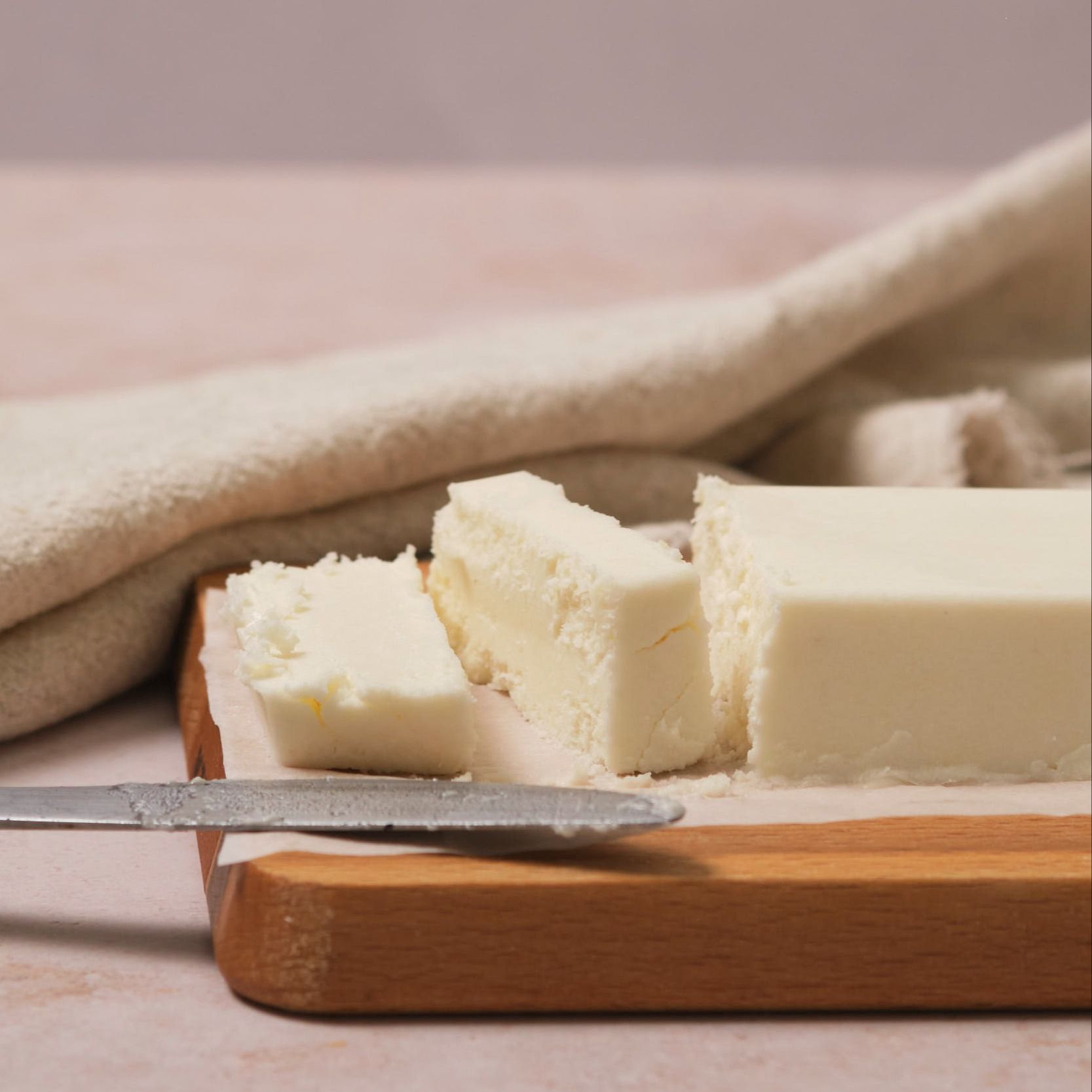 Vegan butter on a wooden slab, sliced.