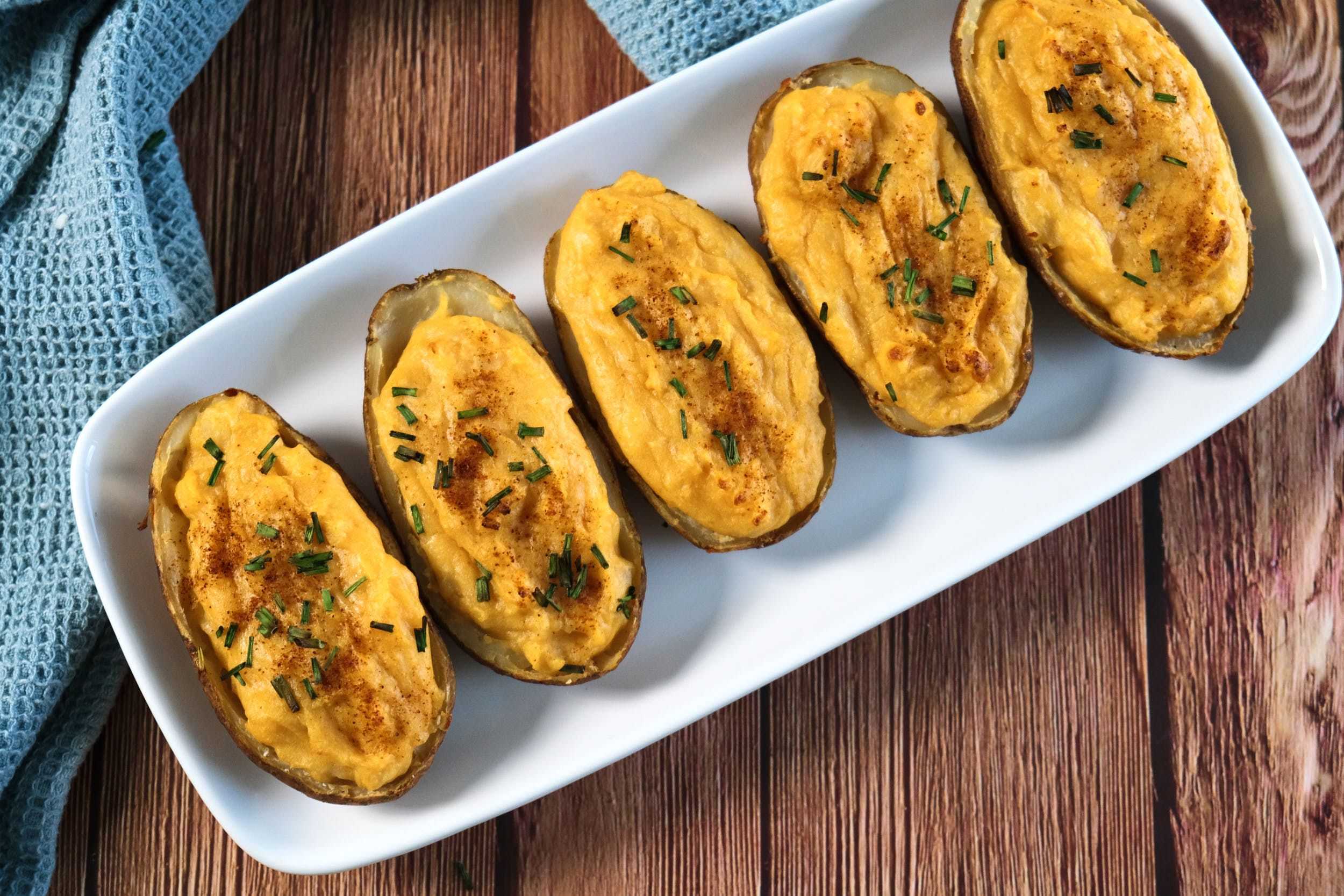 A top-down view of vegan twice-baked potatoes on a platter.