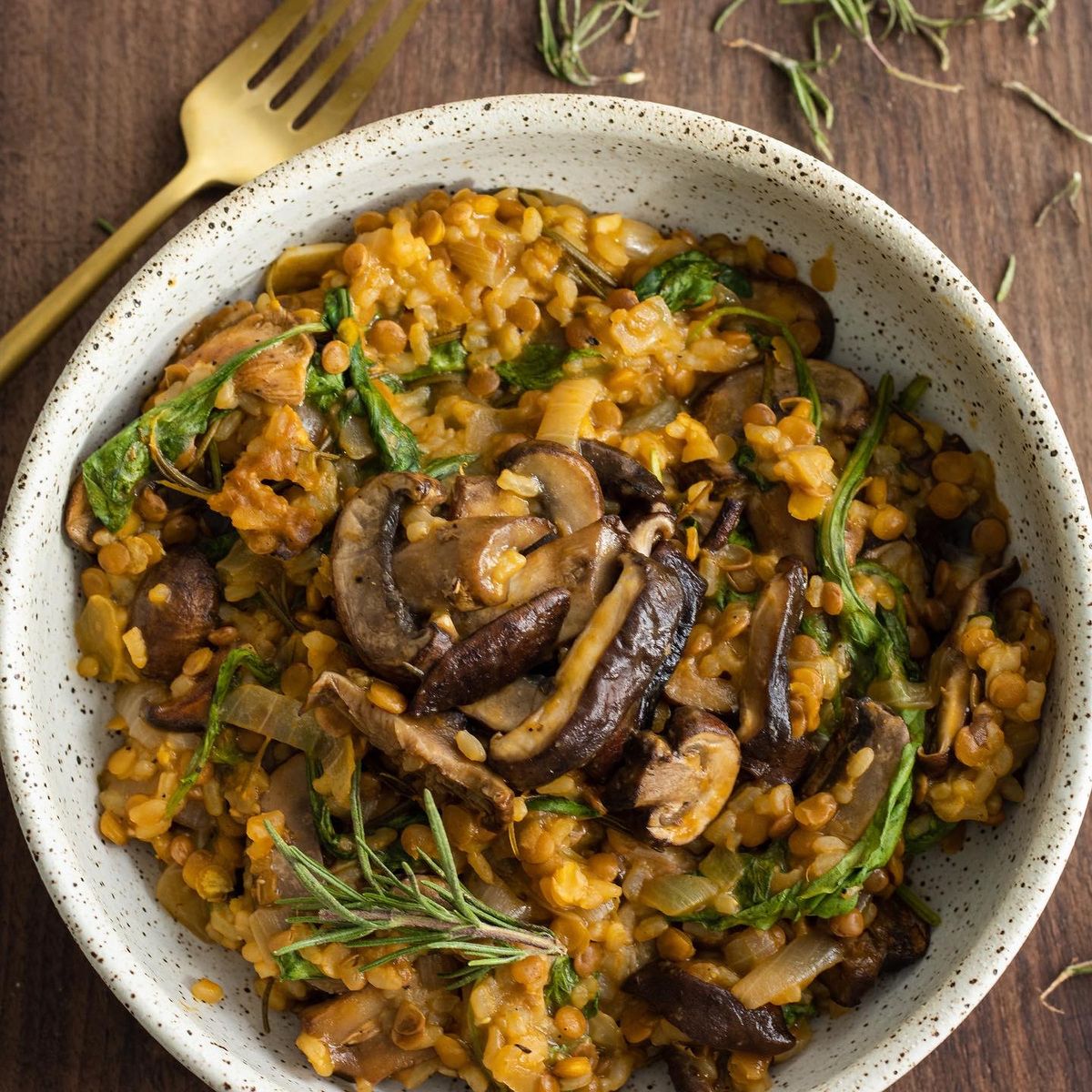 Vegan mushroom lentil risotto in a bowl with a fork. 