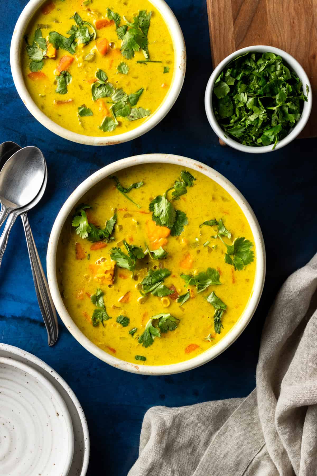 A top-down view of two bowls of red lentil sweet potato soup.
