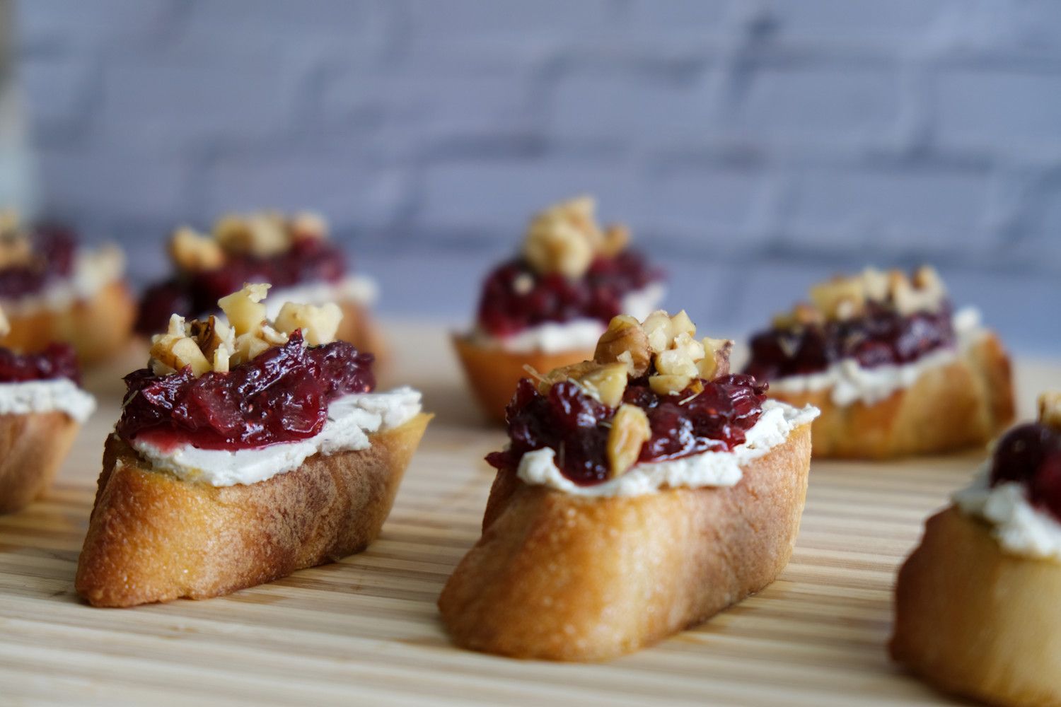 Cranberry and cashew cheese crostini on a cutting board