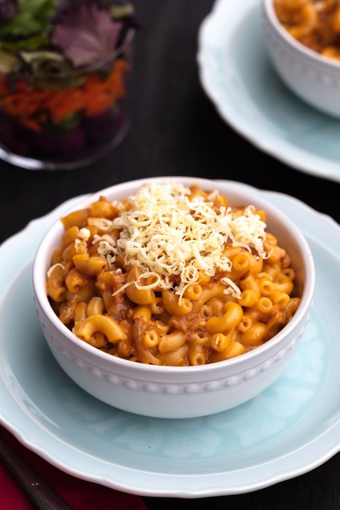 Vegan hamburger helper in a bowl, topped with shredded vegan cheese. 