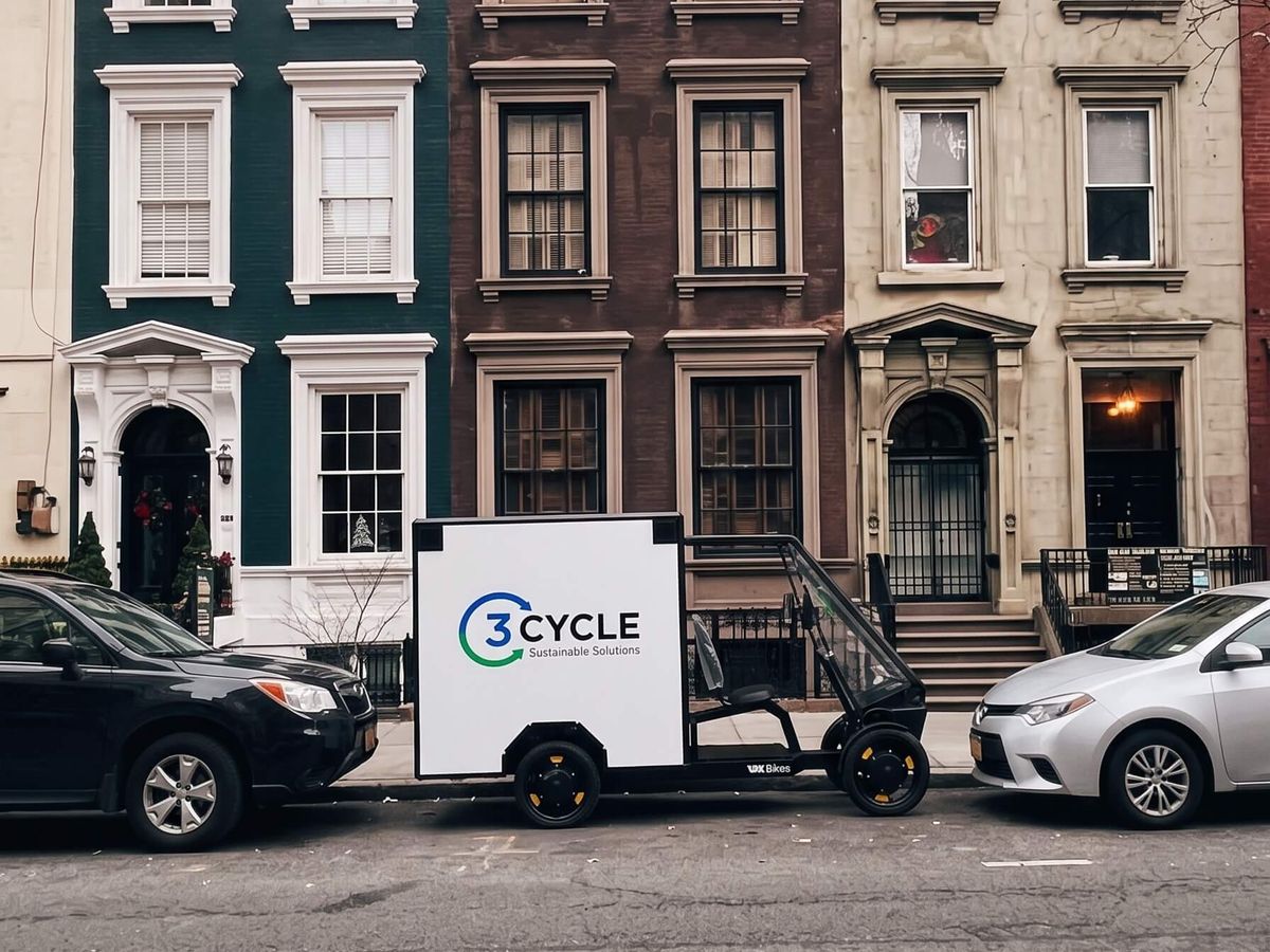 3Cycle electric cargo trike parked outside a row of townhouses