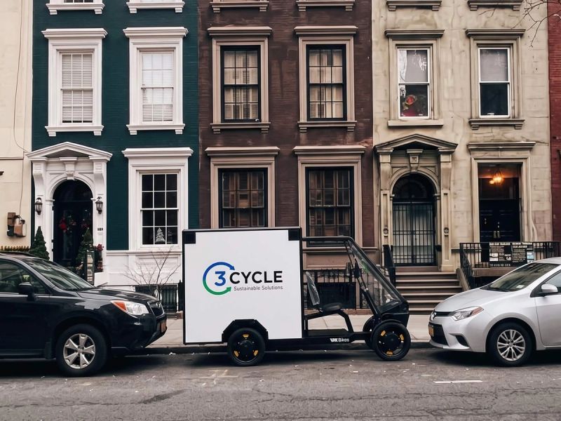 3Cycle electric cargo trike parked outside a row of townhouses