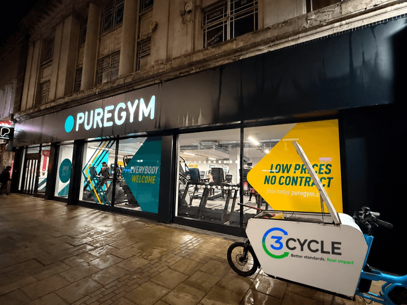 3Cycle cargo bike outside a PureGym shopfront at night
