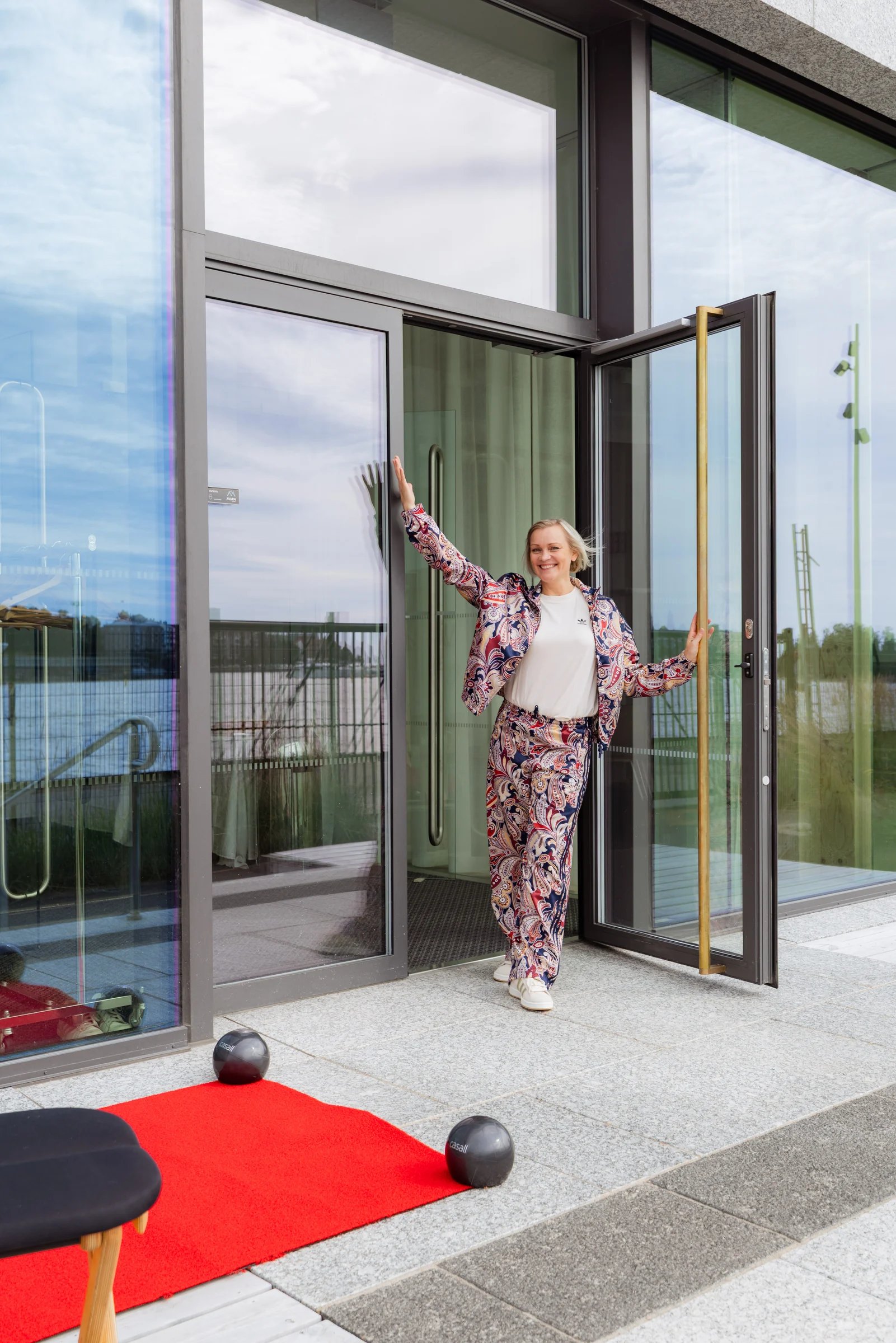 Ohjaaja Pilates Ateljén sisäänkäynnillä Katajanokalla, punainen matto ovella