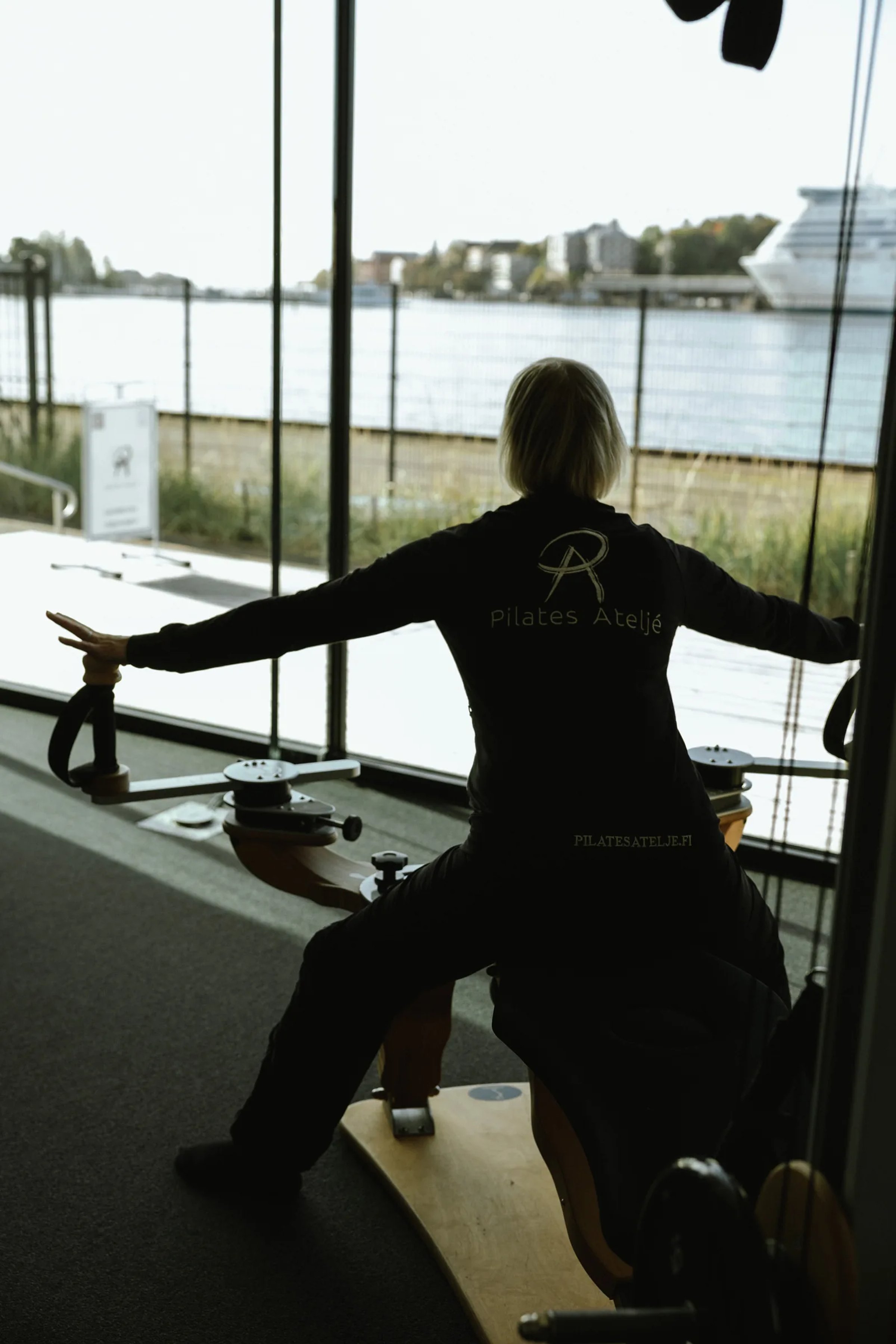 Harjoittelua GYROTONIC®-laitteella Pilates Ateljén salissa, taustalla meri