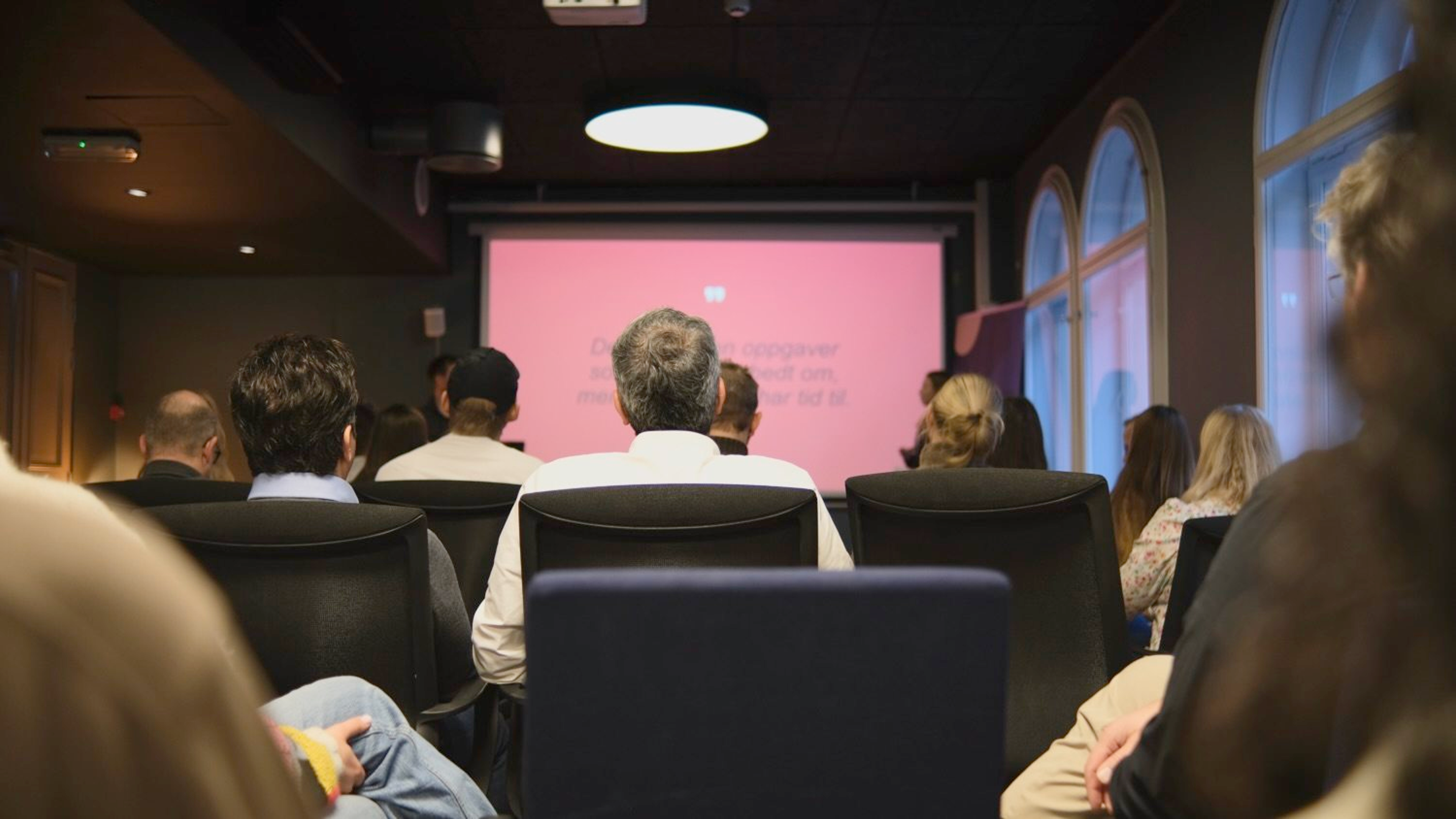 Folk som sitter å hører på et foredrag