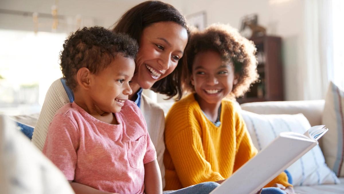 A woman reading a book to kids