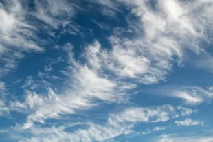 fluffy sunlit clouds in a deep blue sky