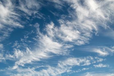 fluffy sunlit clouds in a deep blue sky