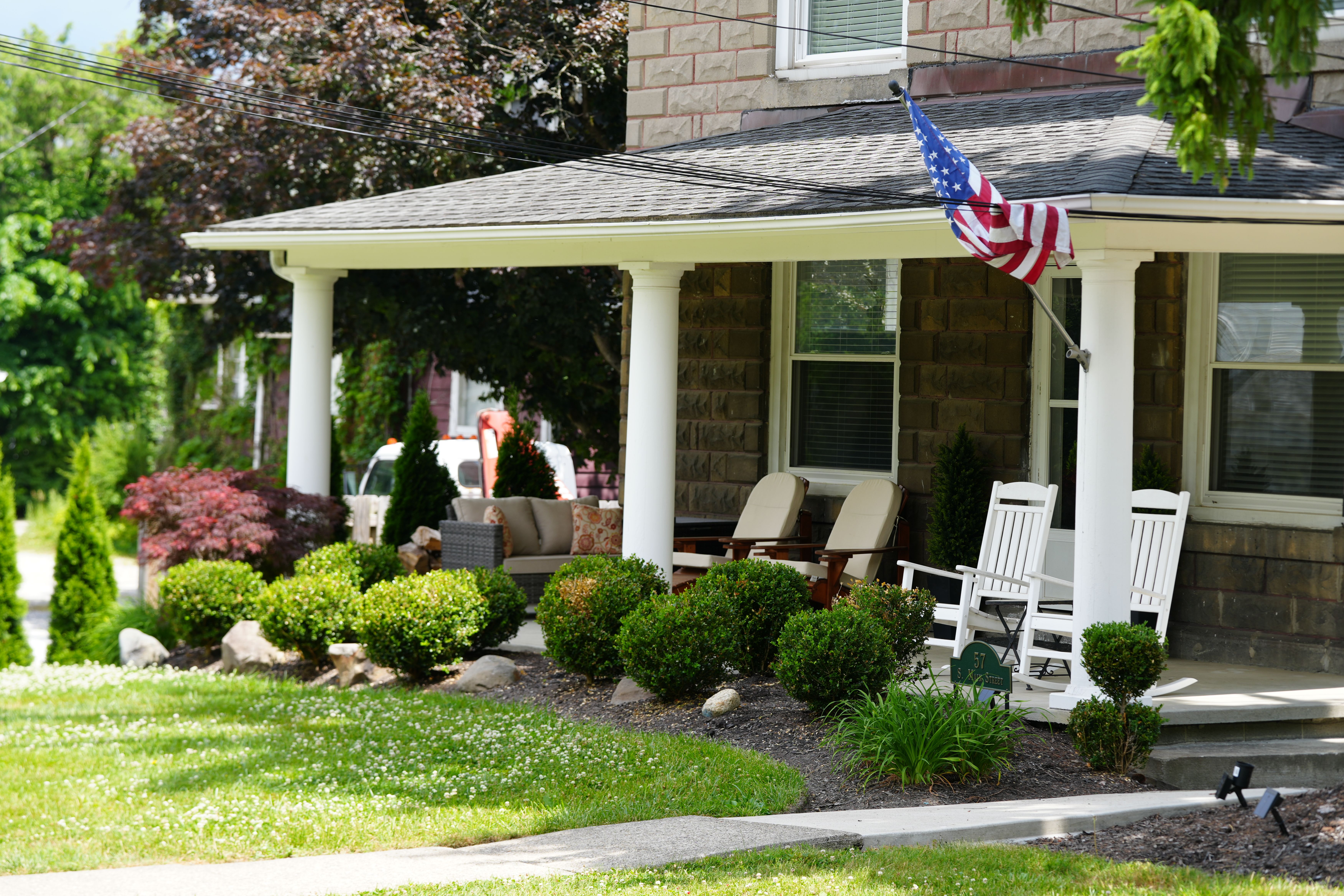 Bright and vibrant plants in foundational bed outside of a beautiful classic home.