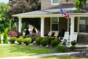 Bright and vibrant plants in foundational bed outside of a beautiful classic home.