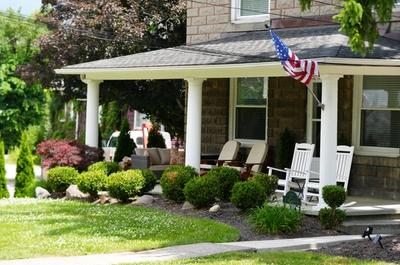 Bright and vibrant plants in foundational bed outside of a beautiful classic home.