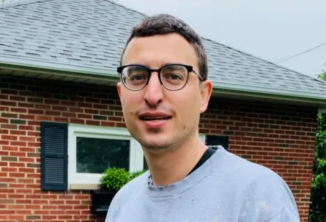 a man standing in front of his home