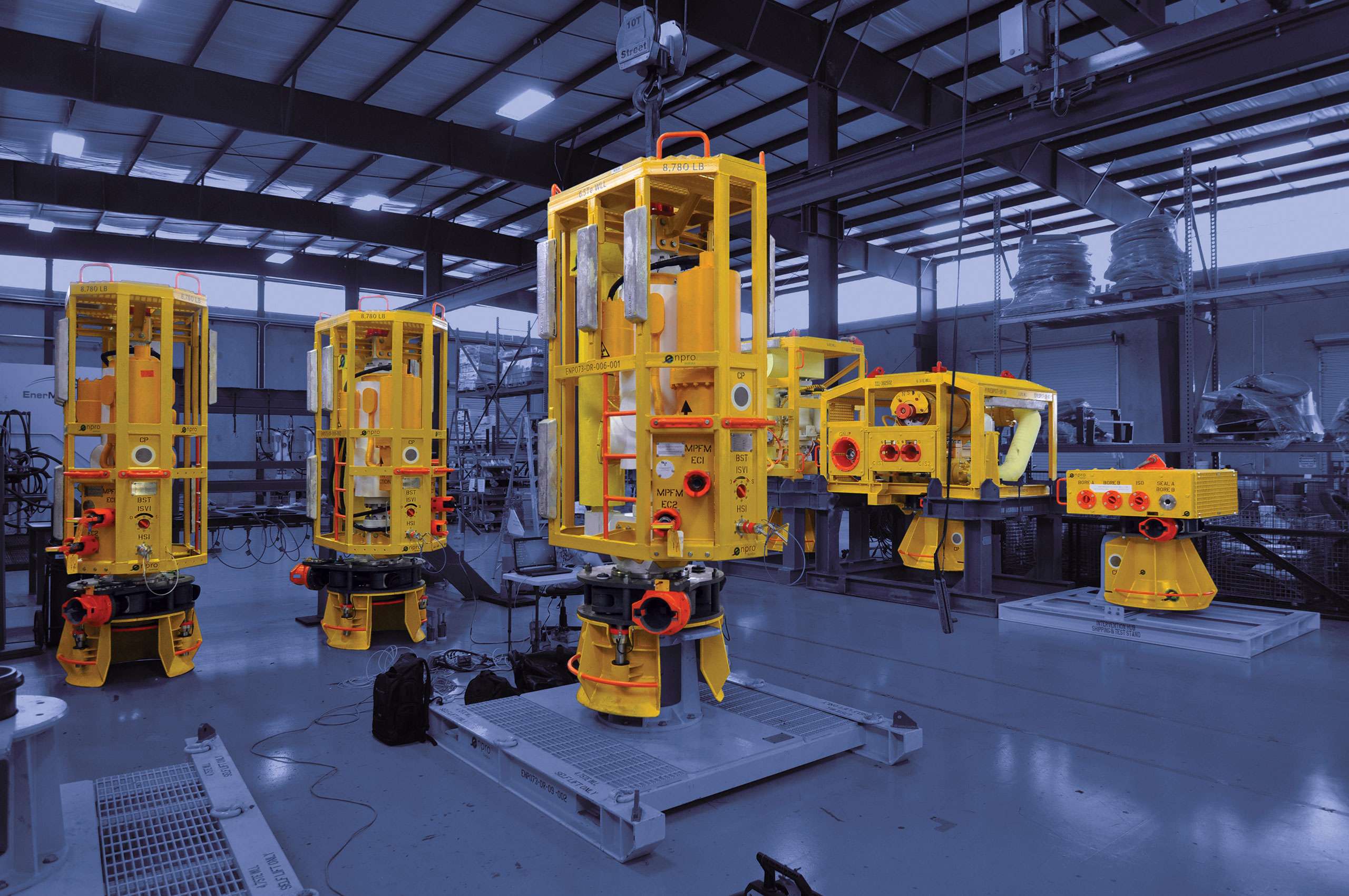 Yellow painted subsea equipment in a warehouse