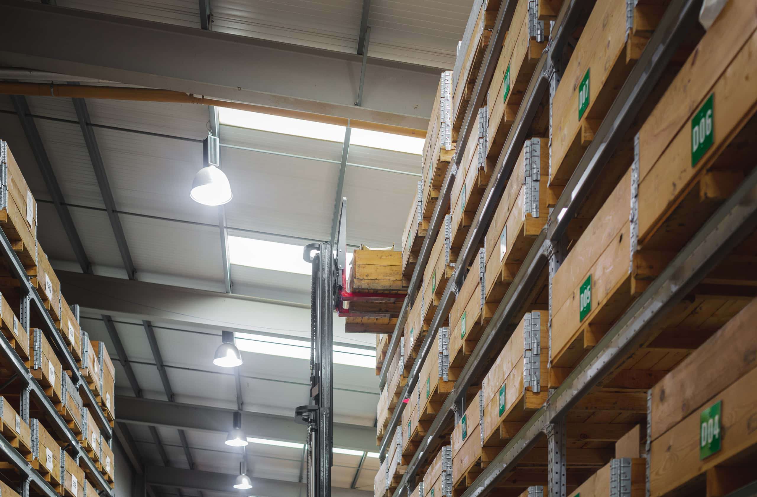 Warehouse shelves with wooden boxes and a fork lift